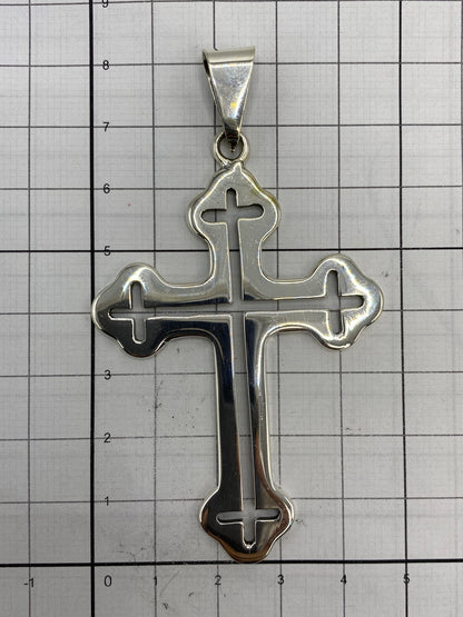 Dije cruz sobre regla métrica mostrando sus dimensiones exactas de 8.2 × 4.7 cm