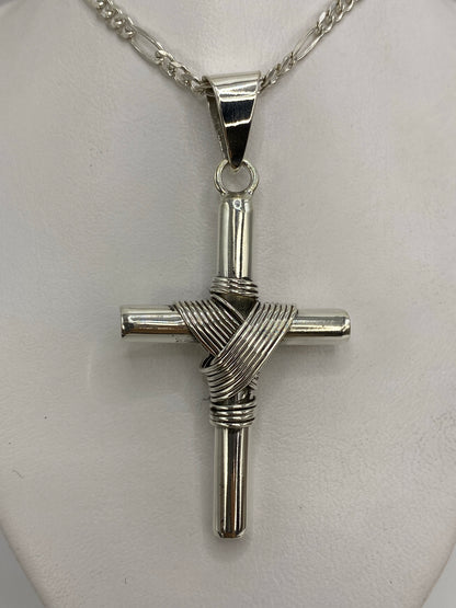 Detalle frontal de la cruz de plata mostrando el entrelazado de hilos artesanal