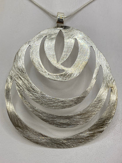Dije de plata 925 sobre fondo blanco, vista frontal, 6 × 5 centímetros