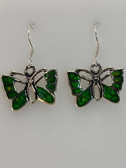 Par de aretes de plata 950 con ópalo de fuego verde, colgando del gancho, viendo la iridiscencia natural de la piedra