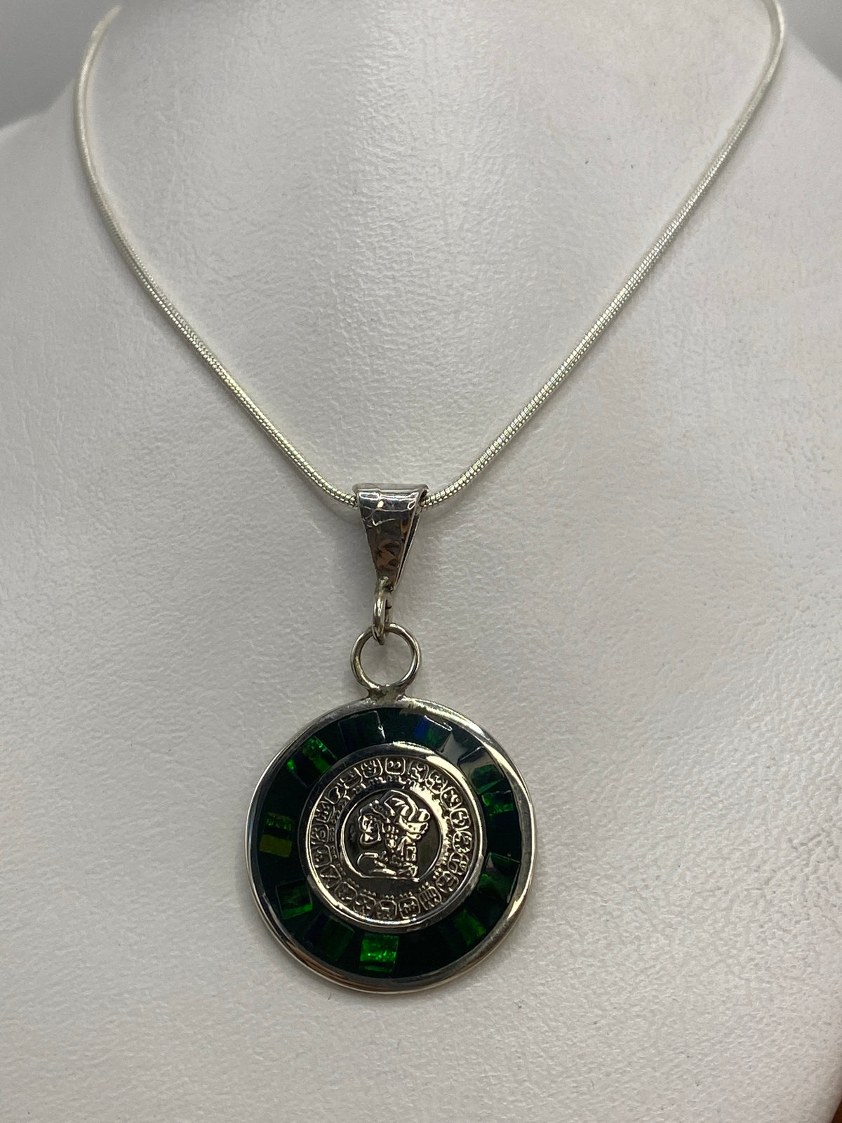 Detalle del símbolo prehispánico grabado en plata con ópalo engastado