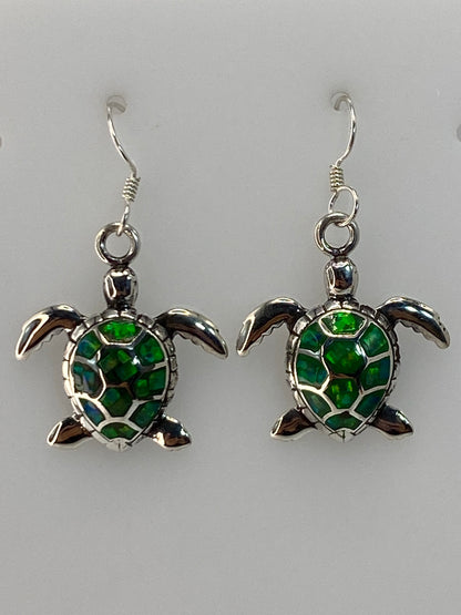 Par de aretes de plata con tortuga marina y Ópalo de Fuego verde limón en las orejas de una mujer