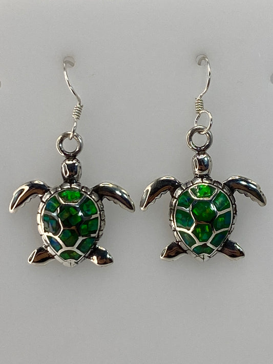 Par de aretes de plata con tortuga marina y Ópalo de Fuego verde limón en las orejas de una mujer