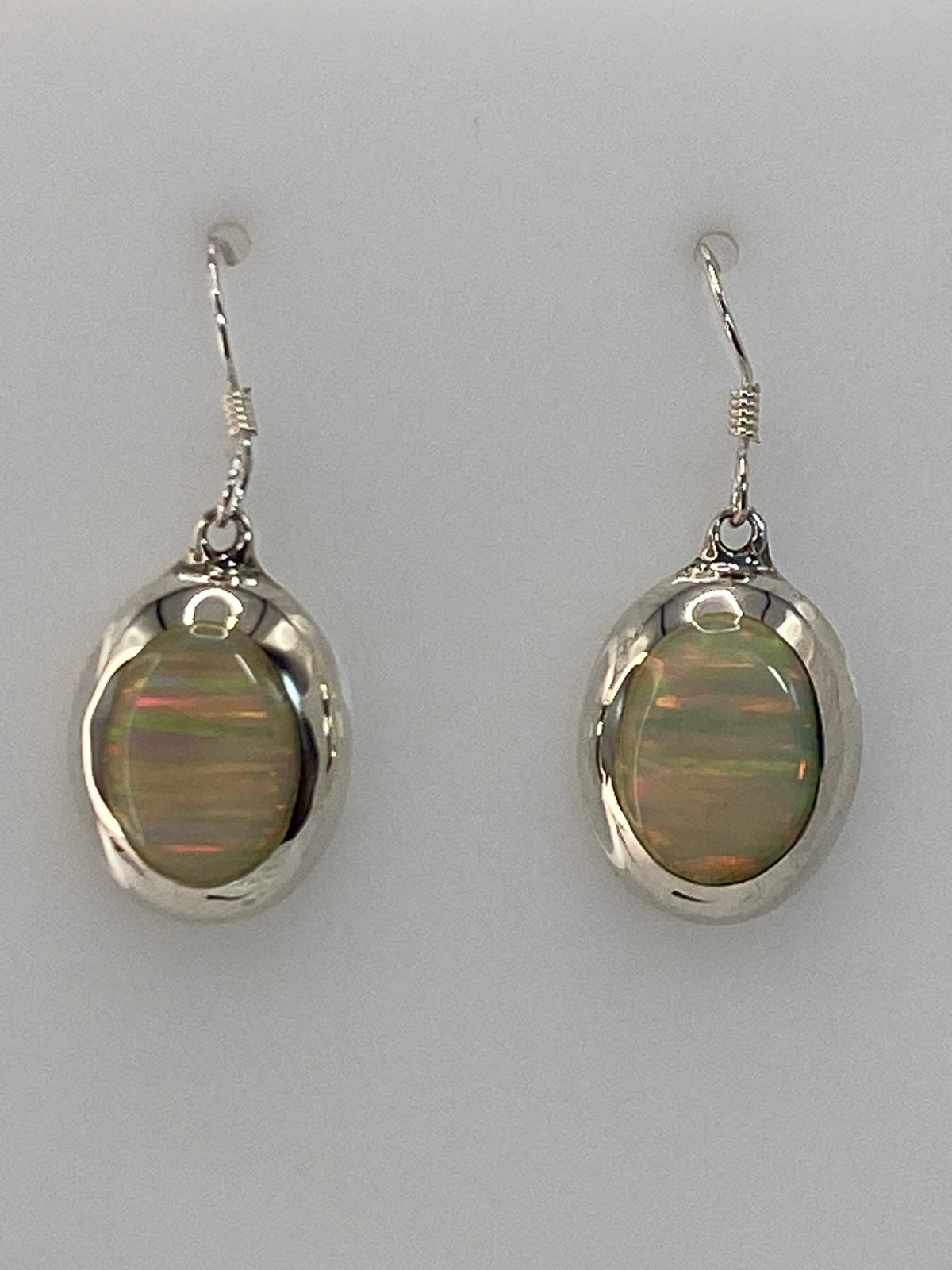 Par de aretes de plata con ópalo de fuego multicolor en diseño ovalado