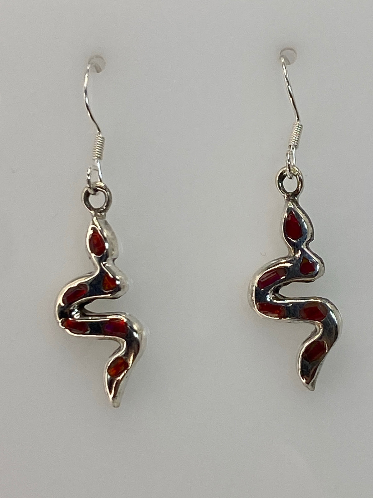 Par de aretes de plata con ópalo de fuego rosa, colgando en gancho de plata 950, sobre fondo blanco