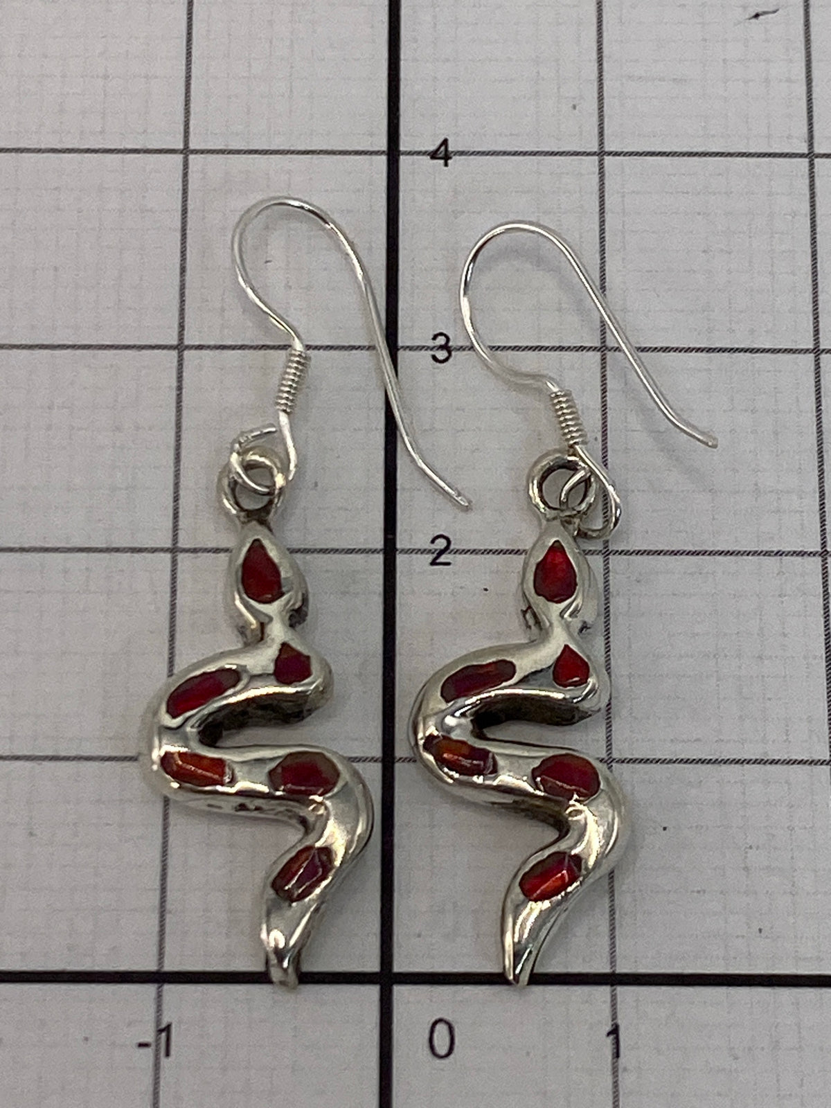 Aretes en la mano mostrando el largo de 3.5 cm y el peso ligero