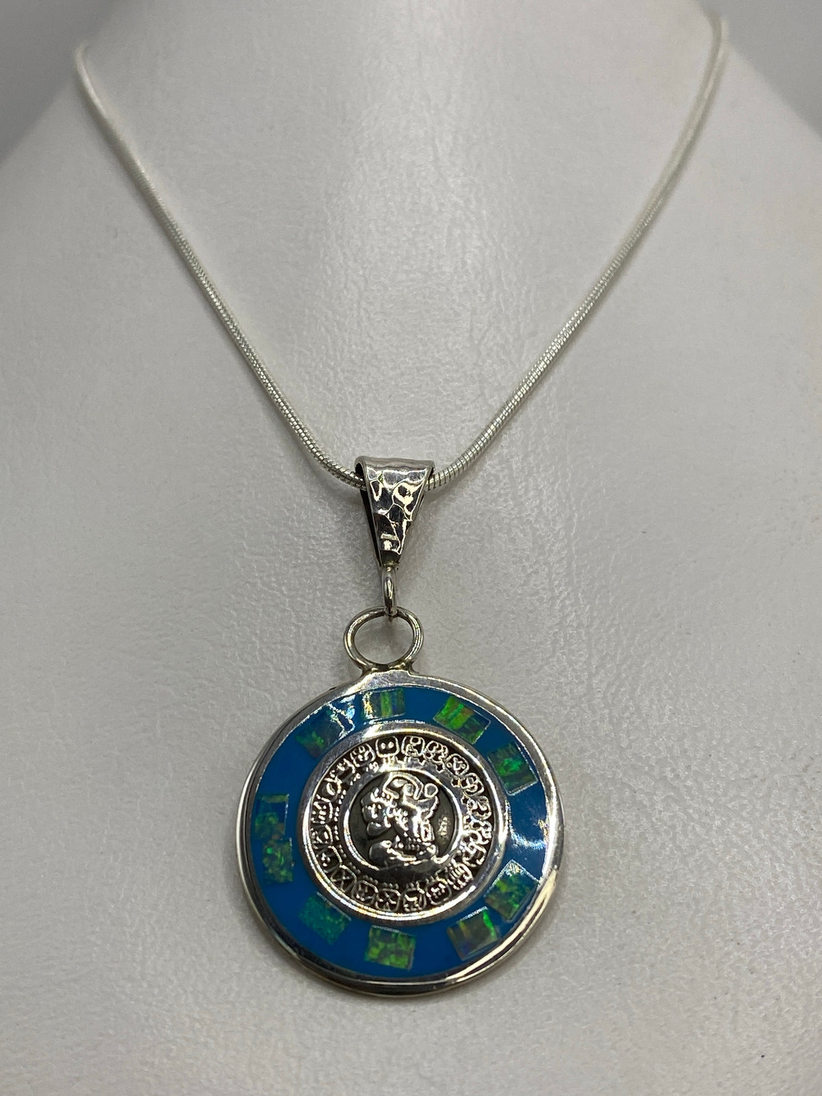 Detalle del calendario asteca grabado en plata 925 con ópalo de fuego