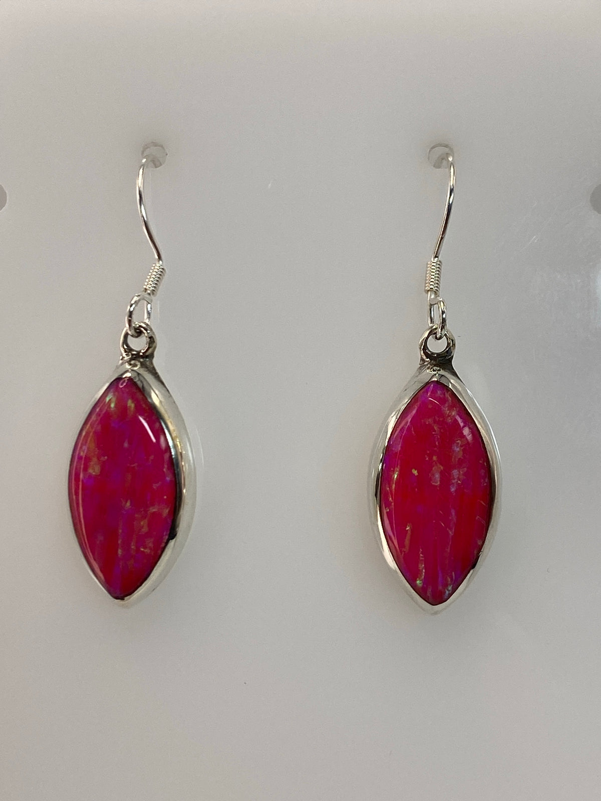 Detalle del engaste a mano del opalo de fuego rosa en aretes de plata