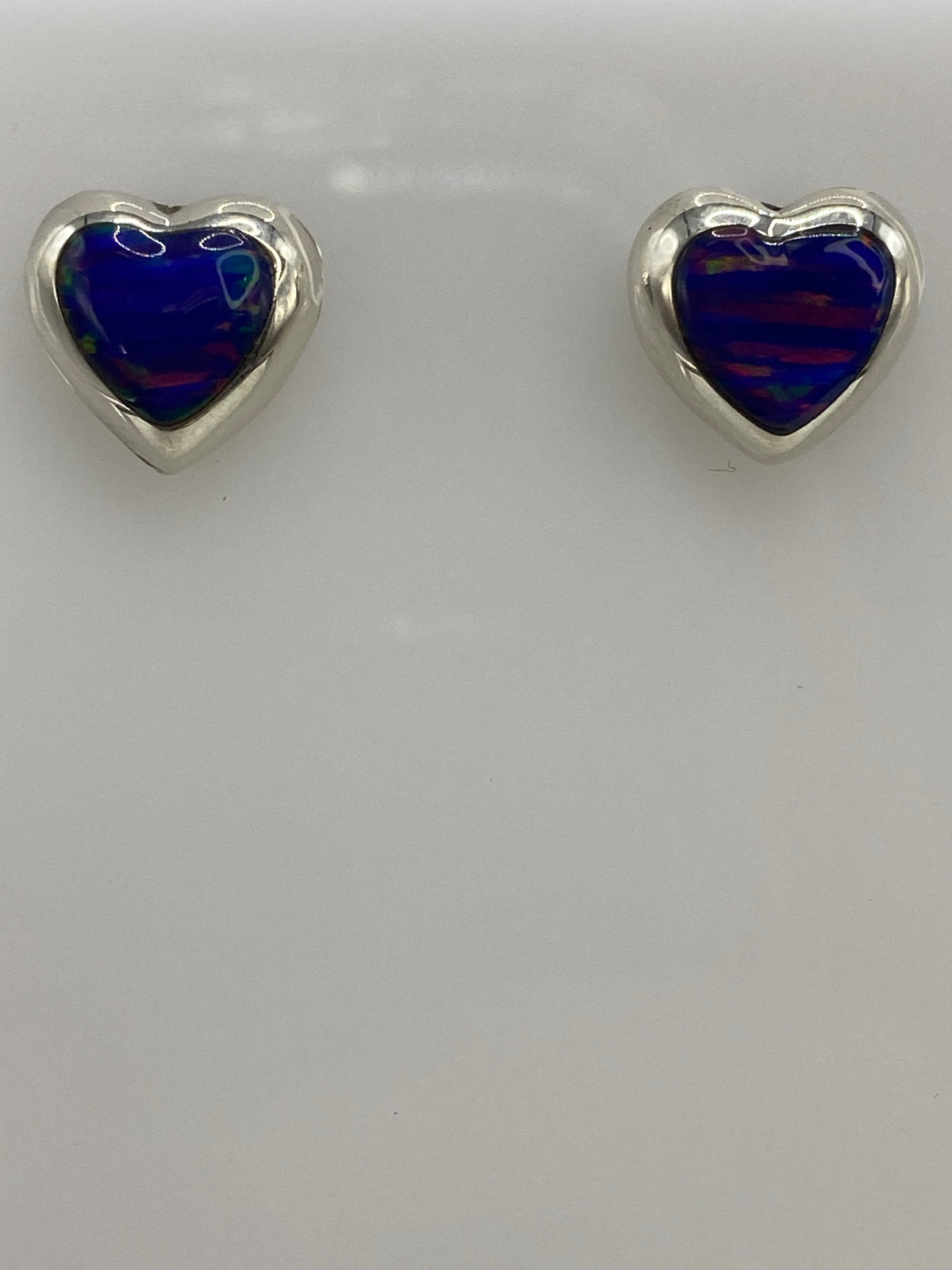 Aretes colocados sobre una regla mostrando medidas de 1.4 cm de largo