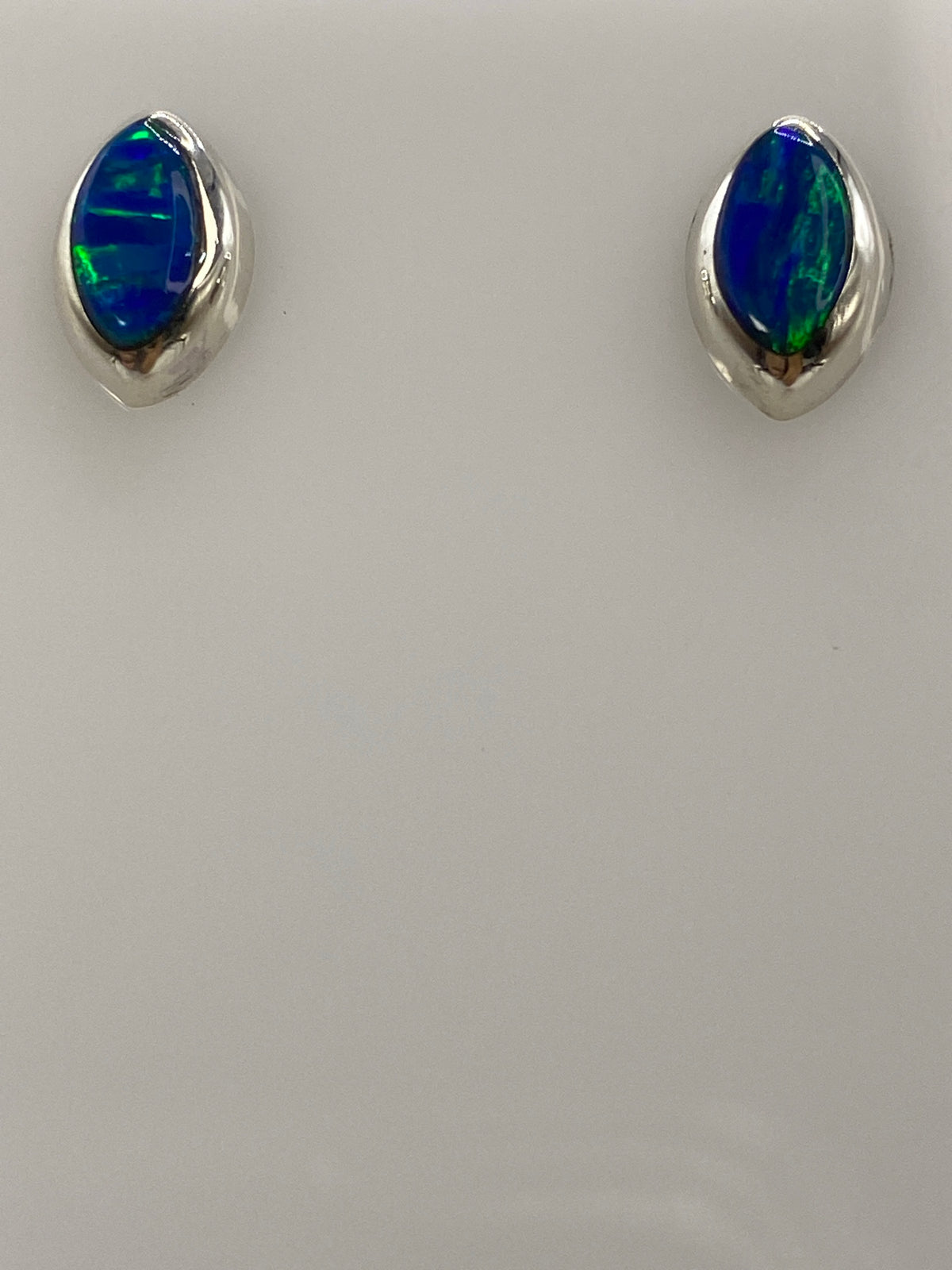 Detalle lateral de arete de 1.3 cm con ópalo azul y poste de plata 925