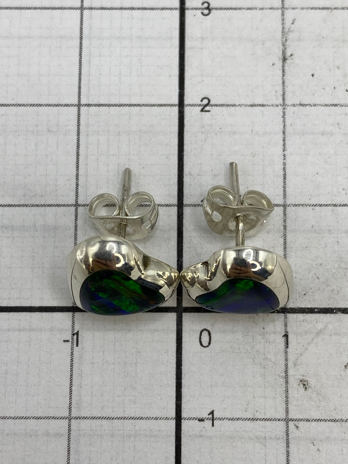 Aretes sobre fondo blanco mostrando el Quinto 925 en la parte trasera