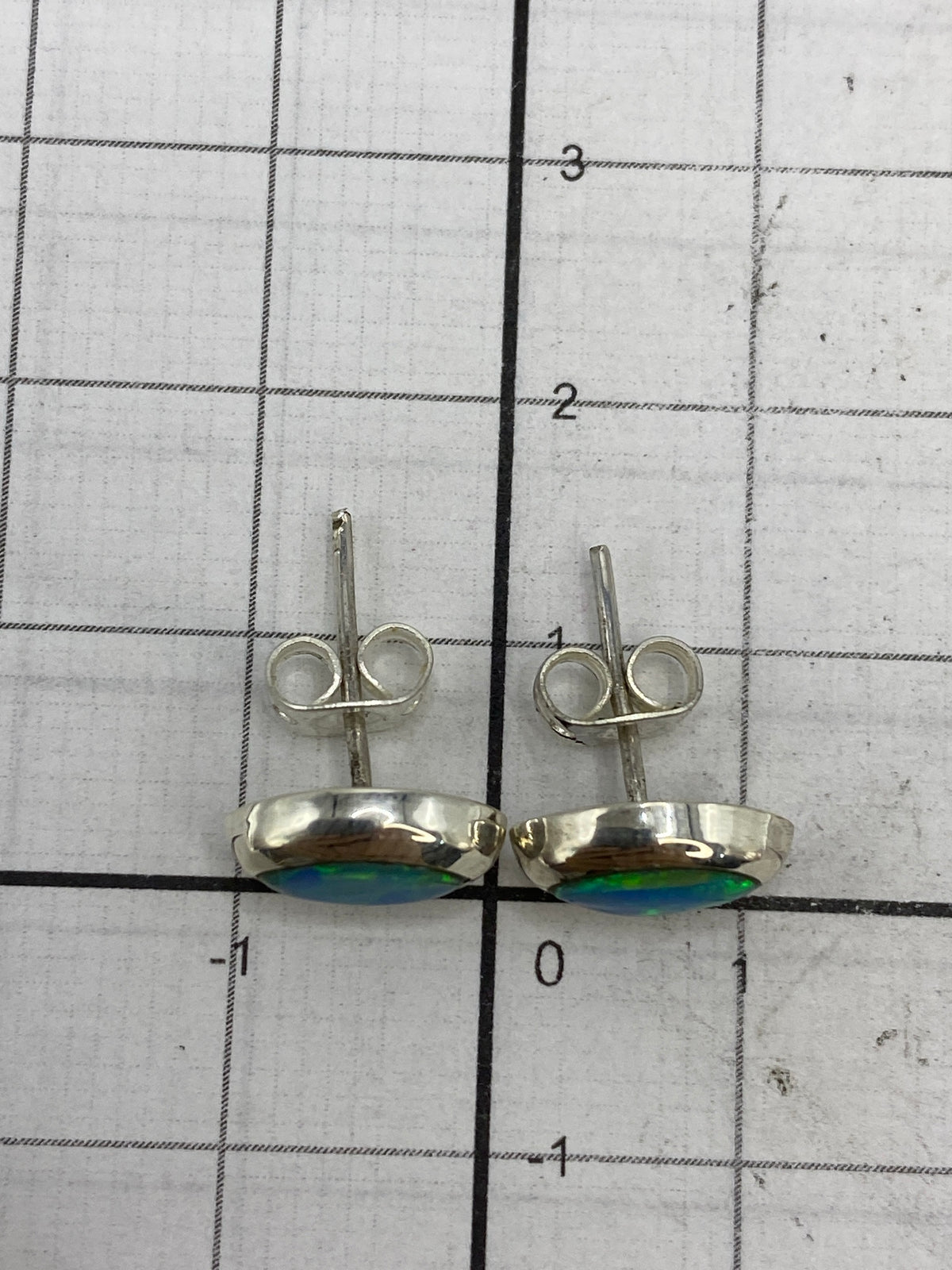 Aretes sobre escala mostrando peso ligero de 1.1 g el par