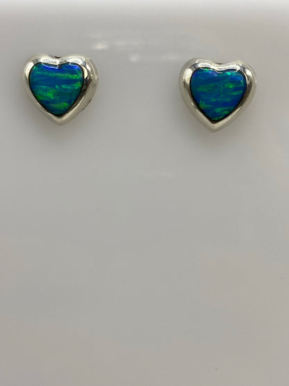 Par de aretes de plata con ópalo de fuego azul, sobre fondo blanco