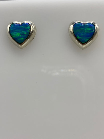 Detalle frontal de los aretes mostrando el color azul del ópalo y el pulido de la plata