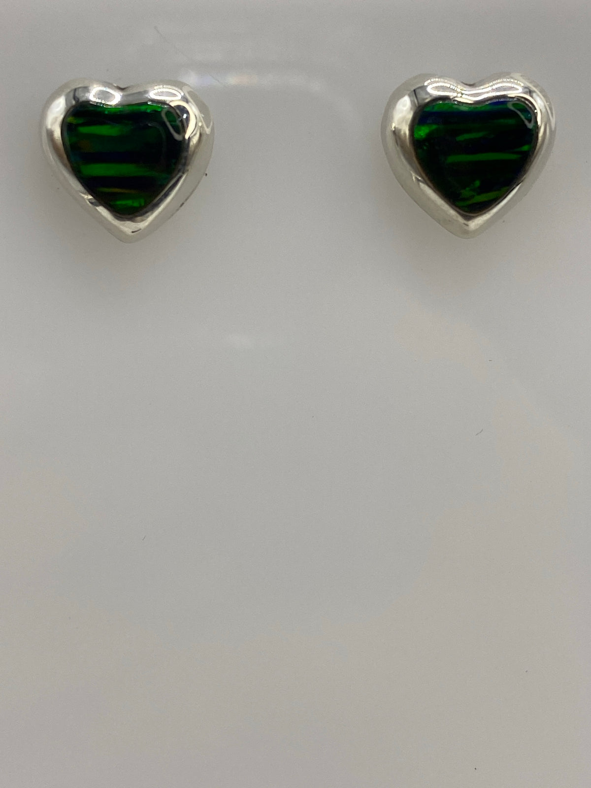 Par de aretes de plata con Ópalo de Fuego verde, vistos de frente mostrando el engaste de la piedra