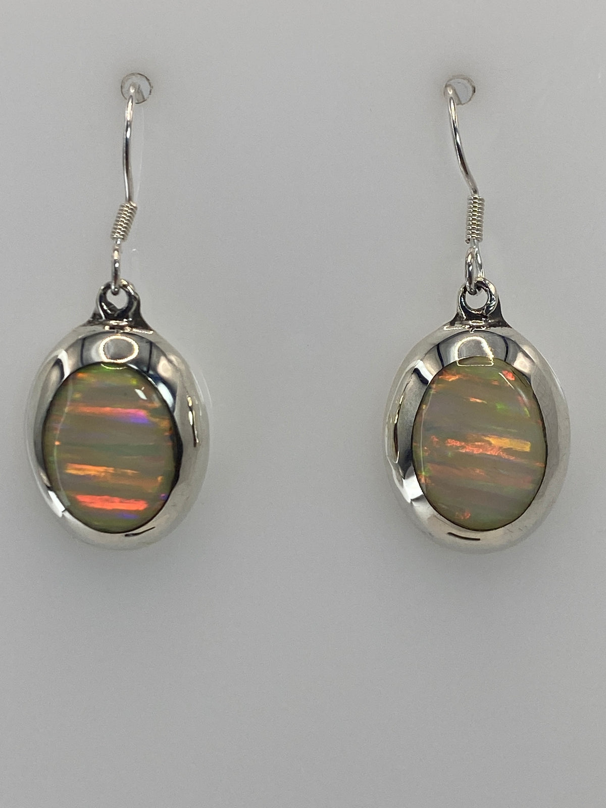 Par de aretes de plata 925 con ópalo de fuego multicolor, gancho plateado, vistos de frente
