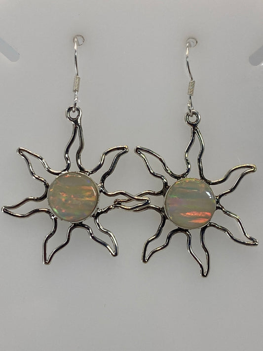 Par de aretes sol de plata 950 con ópalo de fuego naranja y verde, colgando sobre fondo blanco