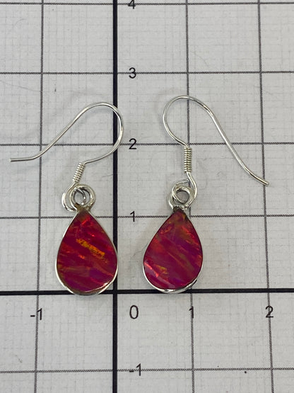 Aretes de ópalo sobre escala de medidas mostrando 2.7 cm de largo