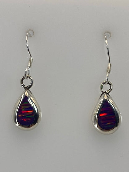 Par de aretes de plata con ópalo de fuego morado, gancho plateado, sobre fondo blanco