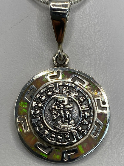 Dije de plata 950 sobre fondo blanco mostrando los glifos aztecas y el Quinto