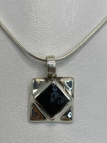 Dije de plata con ónix negra engastado en forma de cuadrado con triángulos reflejantes