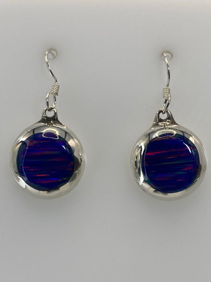 Par de aretes de plata con ópalo de fuego azul profundo, vistos de frente