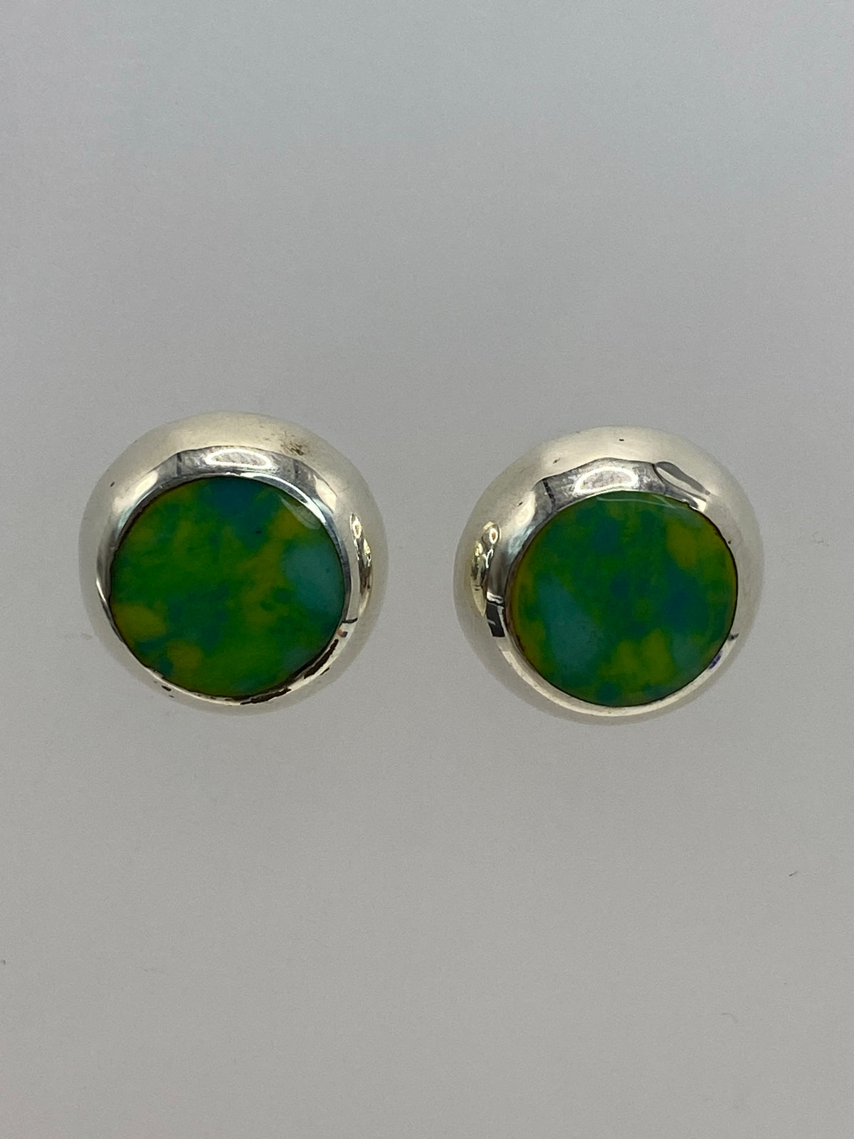 Par de aretes de plata 925 con piedra multicolor en fondo gris