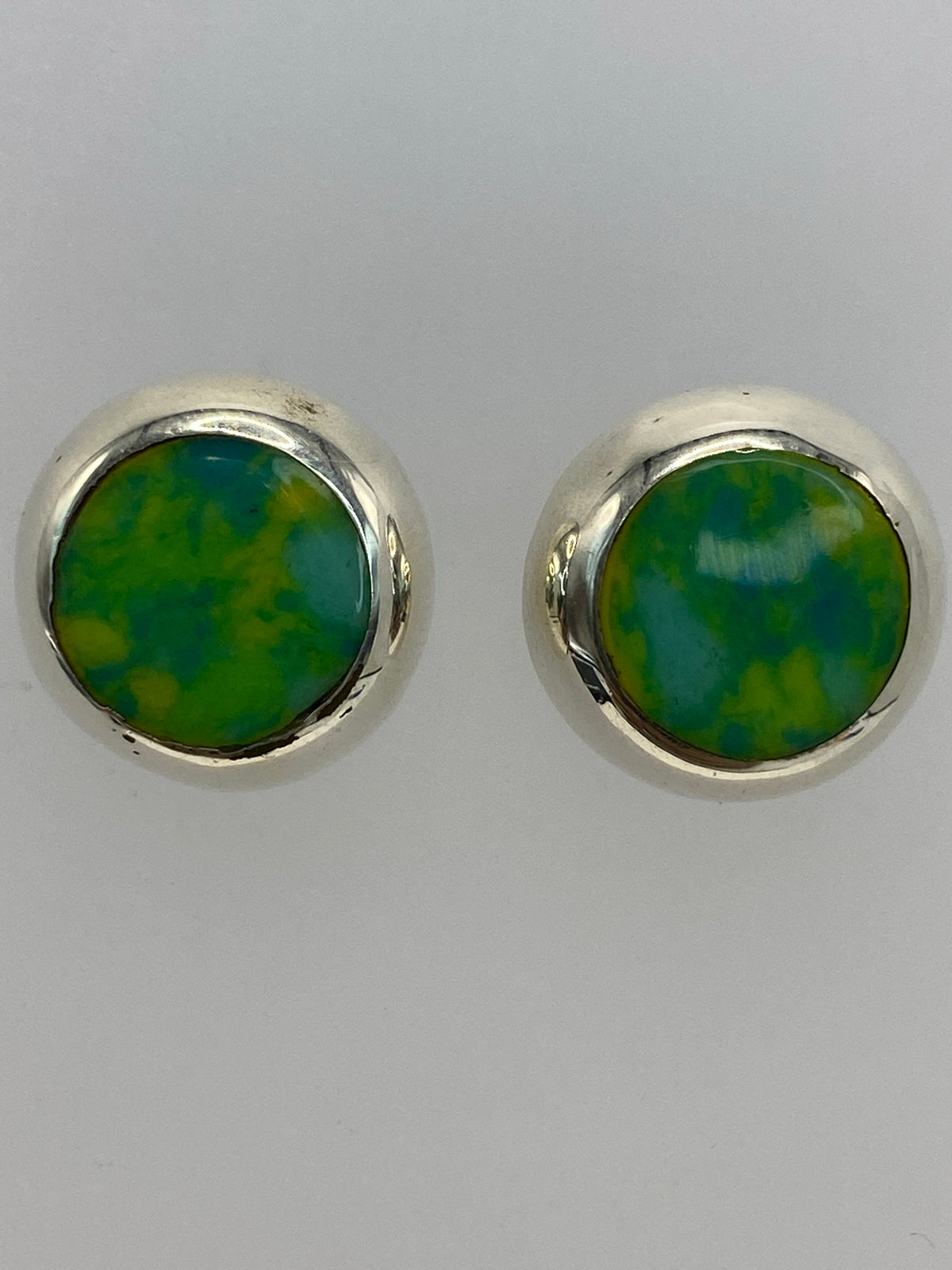 Aretes de plata multicolor sobre escala de medición centimetrada