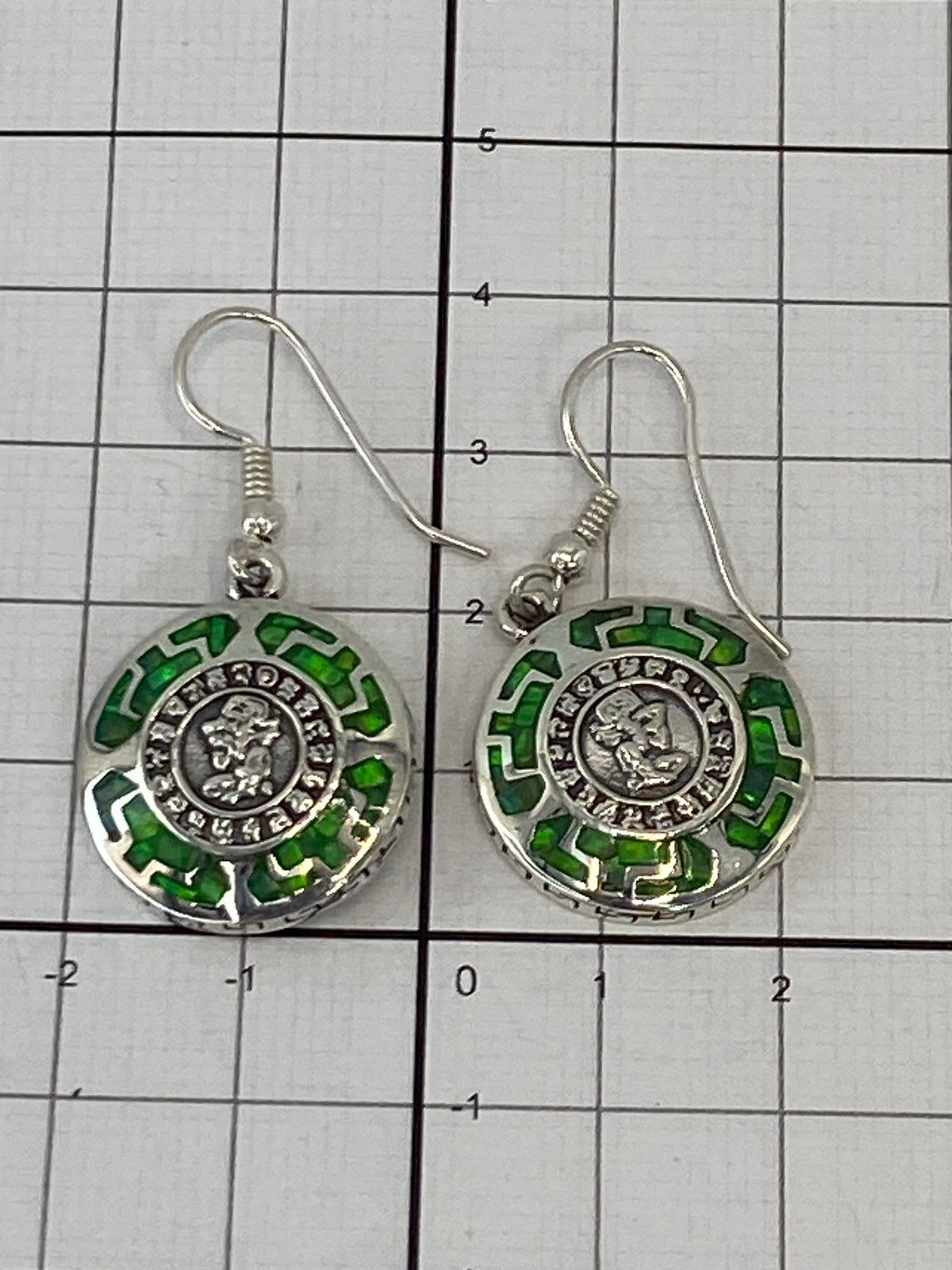 Aretes sobre fondo blanco con gancho de plata quirúrgica visible