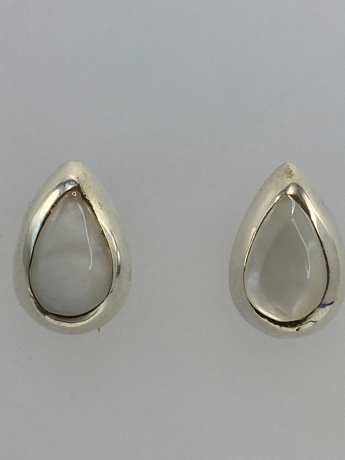 Aretes de perla sobre fondo blanco mostrando el Quinto 925