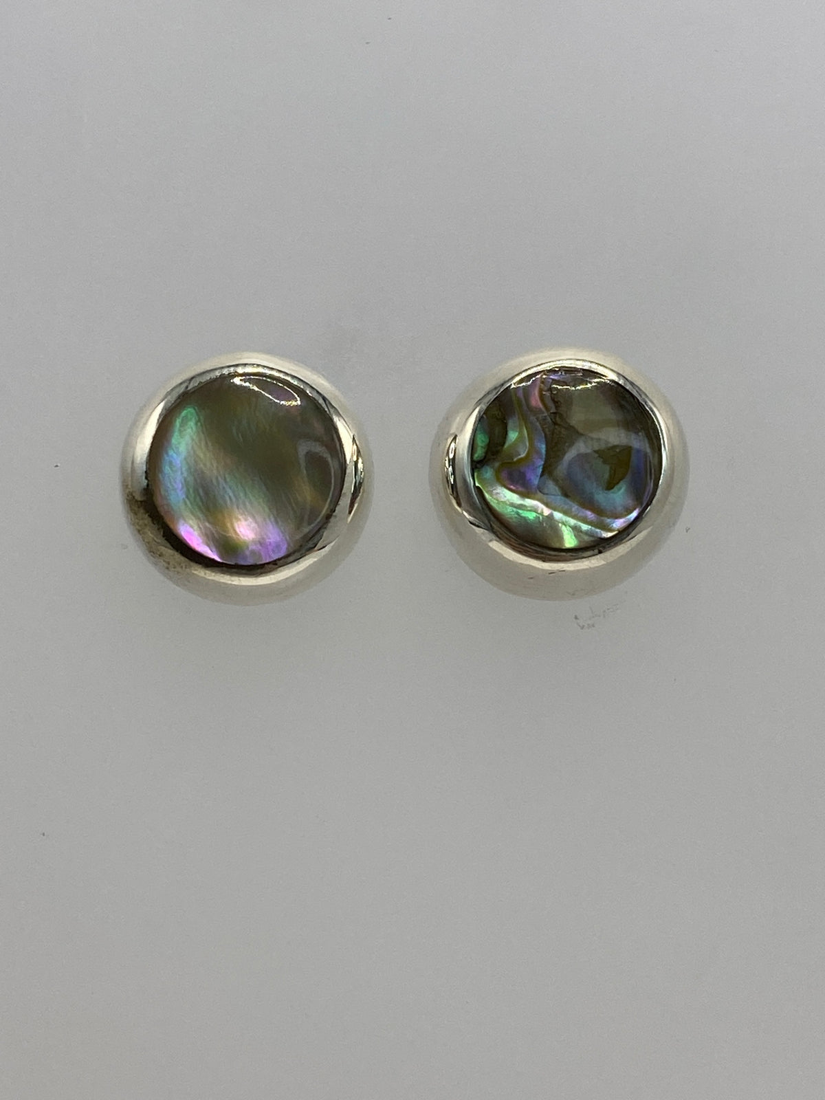 Detalle de arete individual mostrando incrustación multicolor en plata