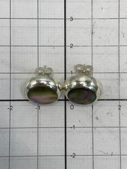 Aretes sobre fondo gris mostrando reflejo de luz en la piedra