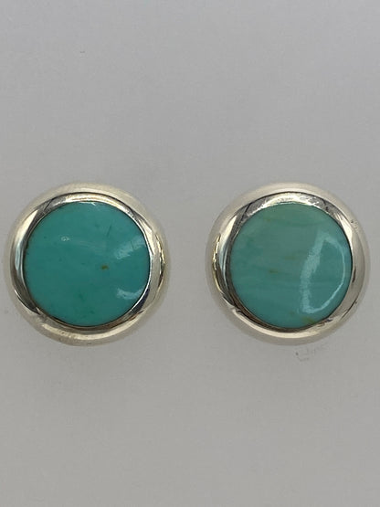 Aretes de plata pequeños con piedra azul cielo vistos desde ángulo frontal