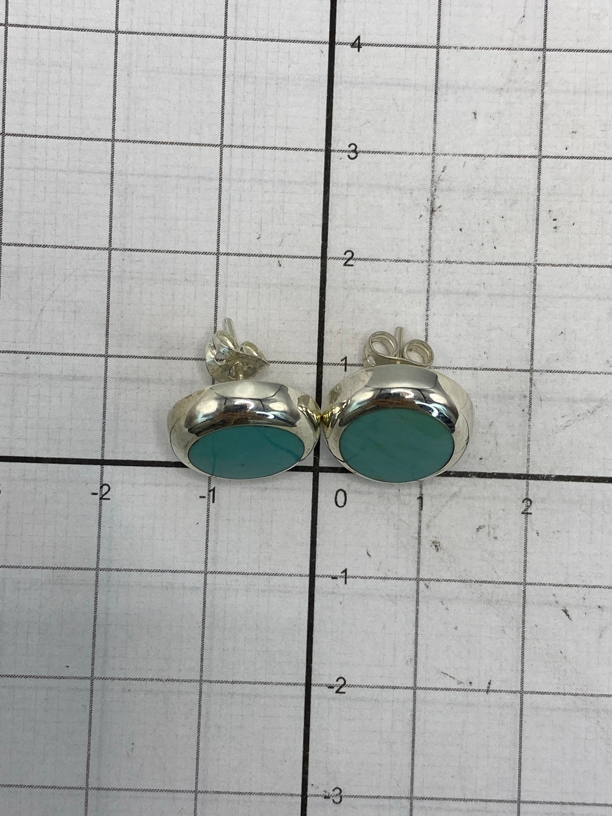 Reverso de los aretes mostrando el cierre y la pureza 925