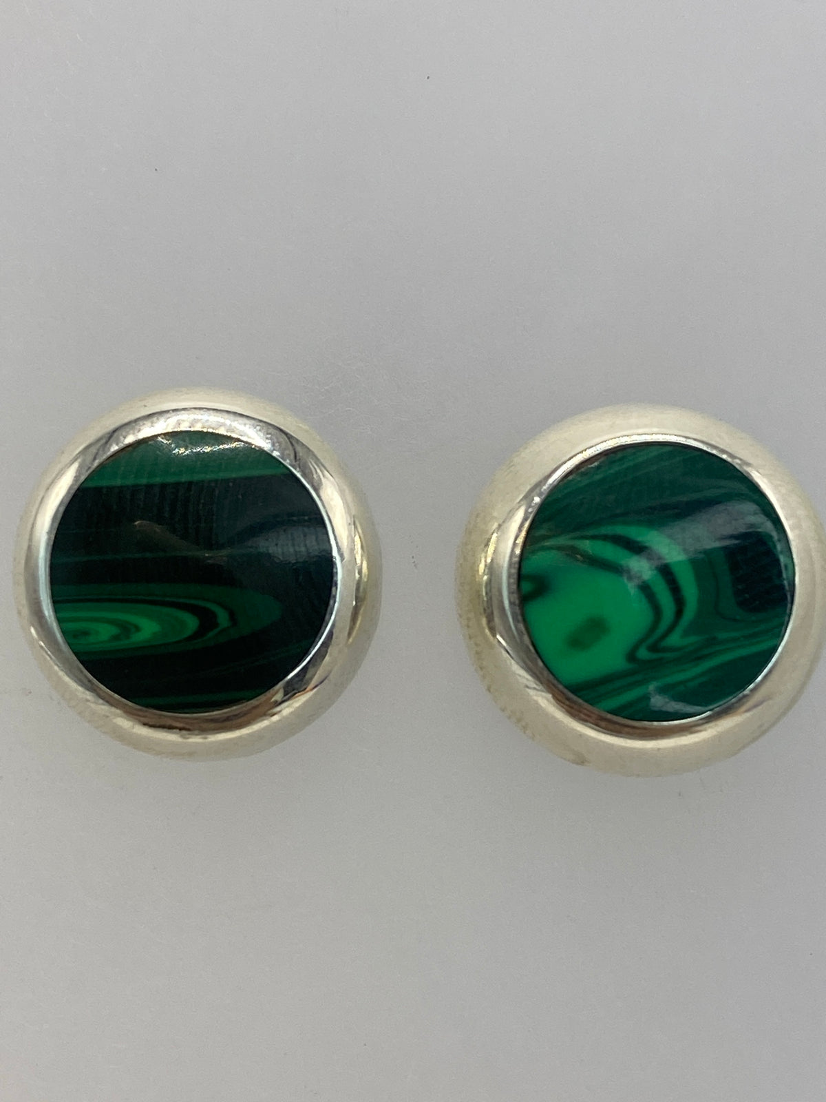 Par de aretes sobre fondo neutral, mostrando el tamaño de 1.3 cm