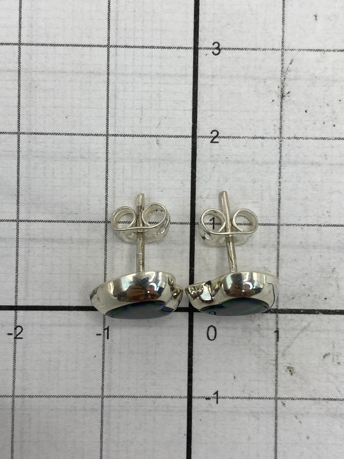 Aretes con escala de medida mostrando 1.3 cm de largo total