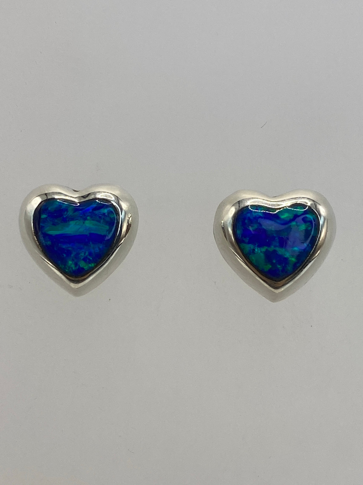 Aretes de plata con ópalo azul profundo en posición frontal