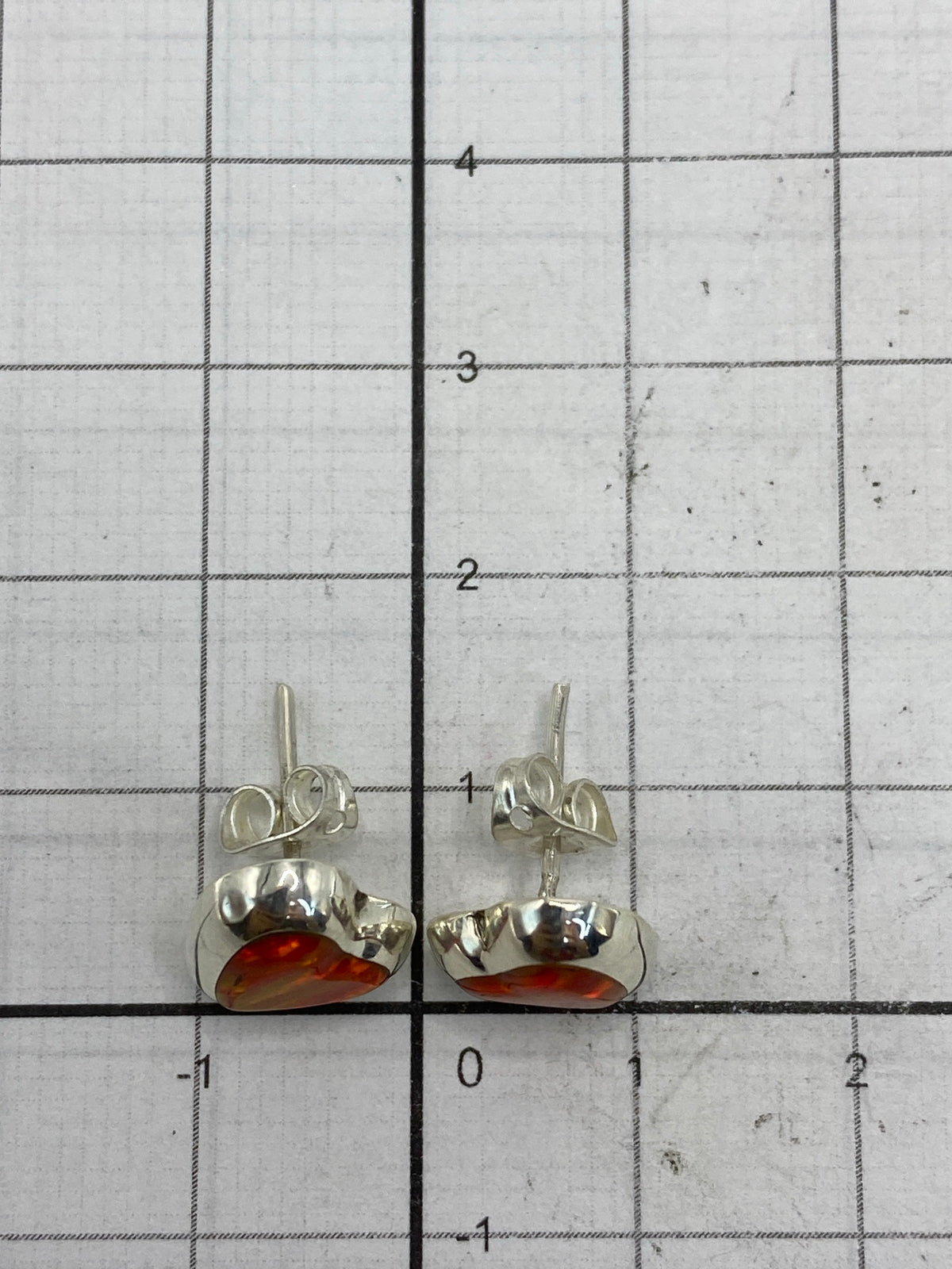 Aretes de Taxco sobre fondo blanco mostrando el sello 925 en los postes