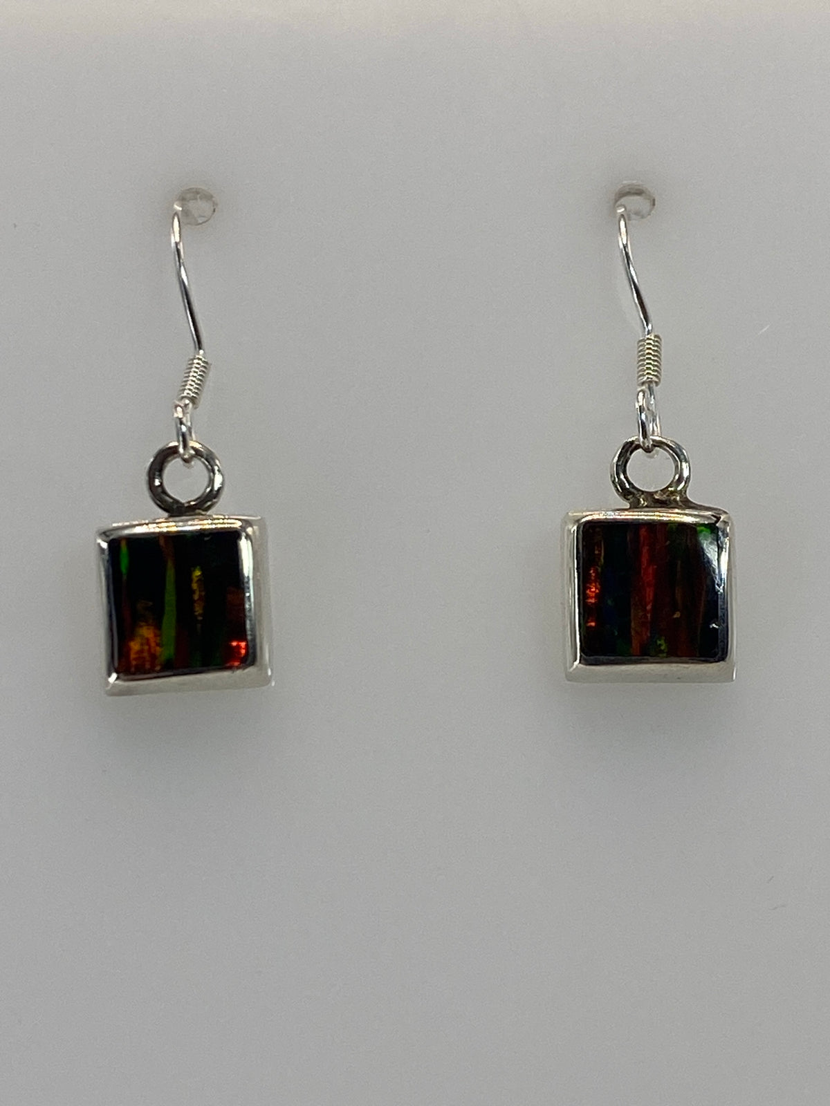 Detalle de los aretes mostrando el ópalo multicolor engastado en plata