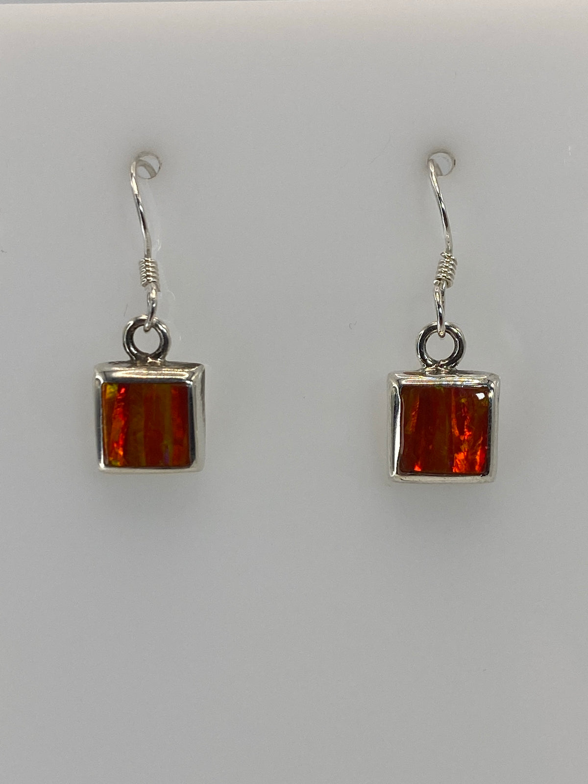 Aretes colgando mostrando el brillo naranja del Ópalo de Fuego