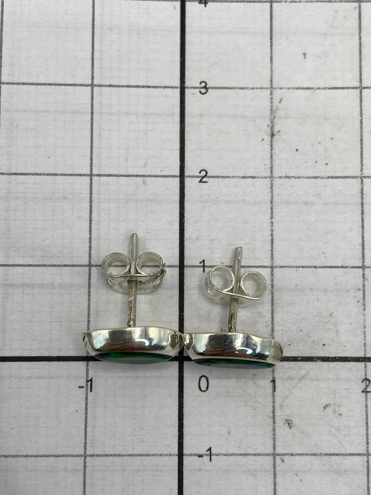 Aretes sobre fondo blanco destacando el color verde del ópalo de fuego