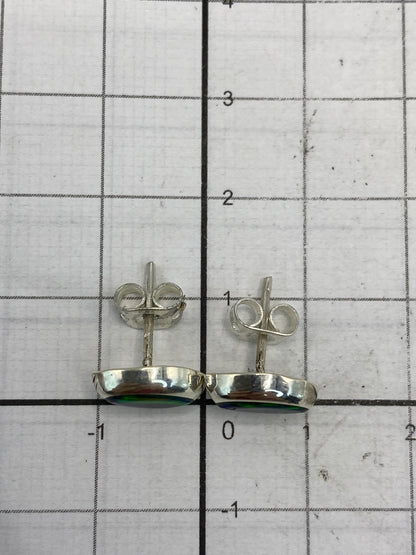 Aretes sobre fondo blanco destacando el color verde del ópalo de fuego