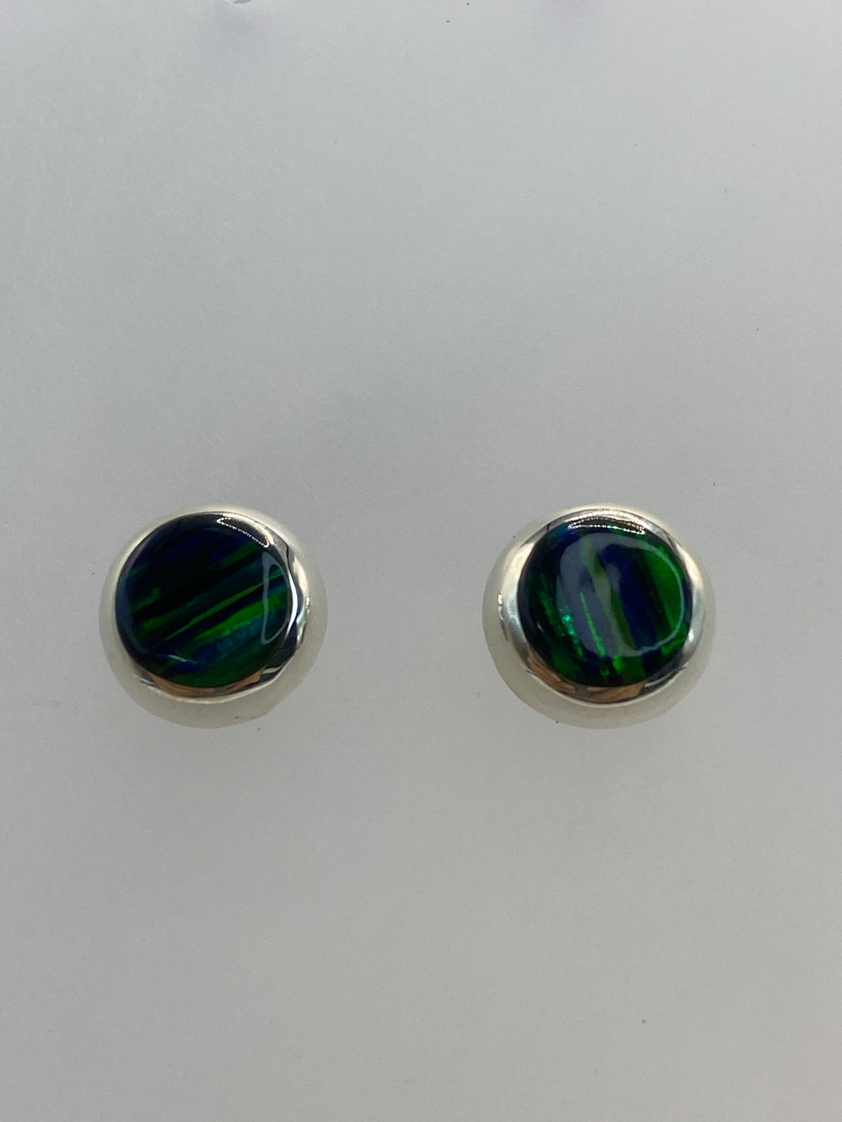 Aretes de plata 925 con incrustación de ópalo de fuego verde, vista lateral con cierre de postes