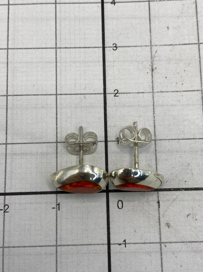 Aretes con opalo de fuego mostrando los reflejos dorados de la piedra
