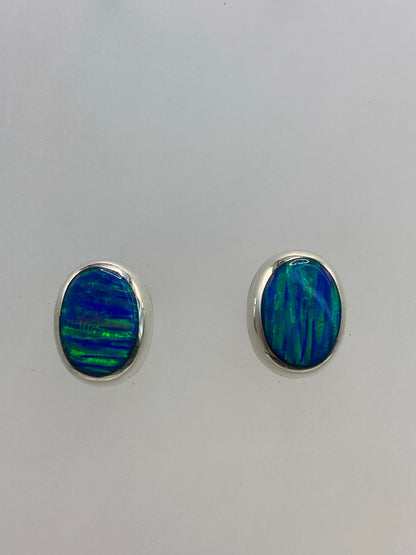 Par de aretes de plata con Ópalo de Fuego azul cielo sobre fondo blanco