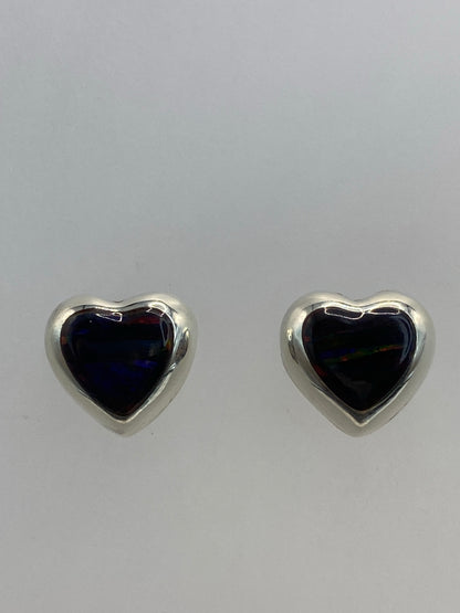 Vista lateral del par de aretes en corazón, con cierre de estuche
