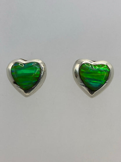 Aretes ópalo de fuego sobre fondo blanco mostrando el brillo verde limón