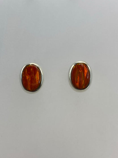 Aretes de plata con ópalo de fuego naranja en par, sobre fondo blanco