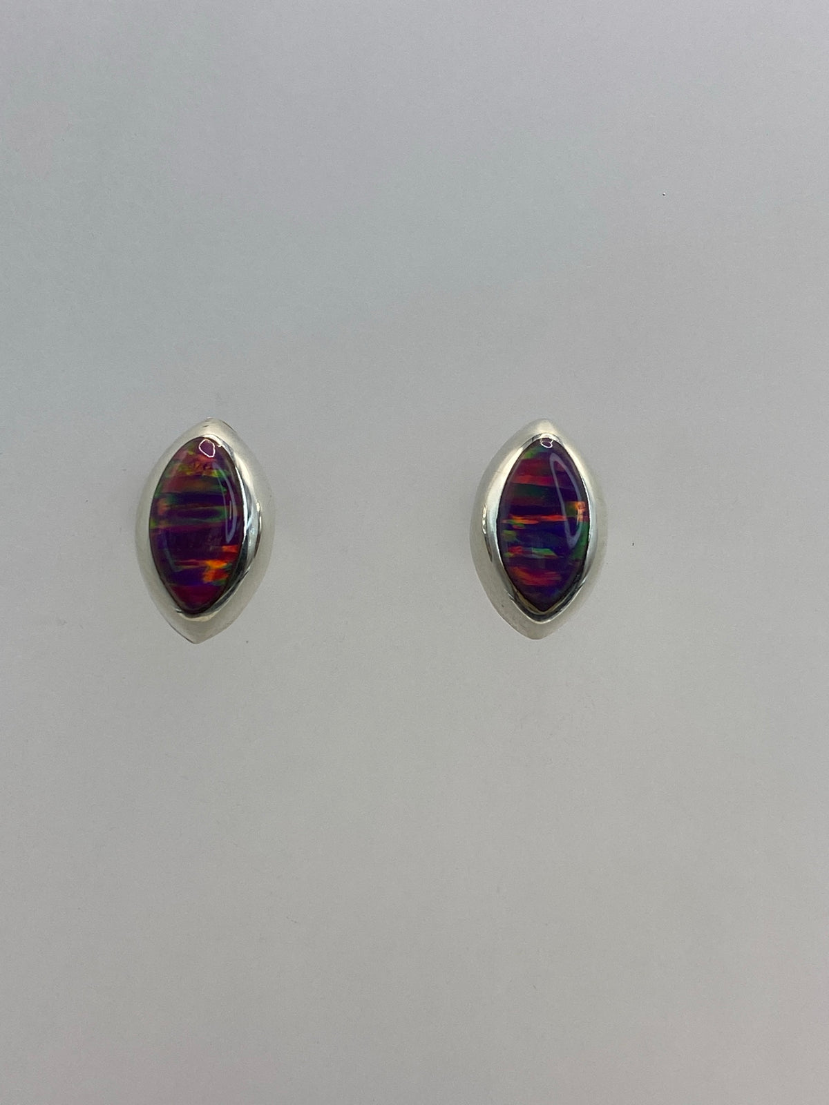 Aretes de plata 925 con ópalo de fuego morado iridiscente, vistos de frente