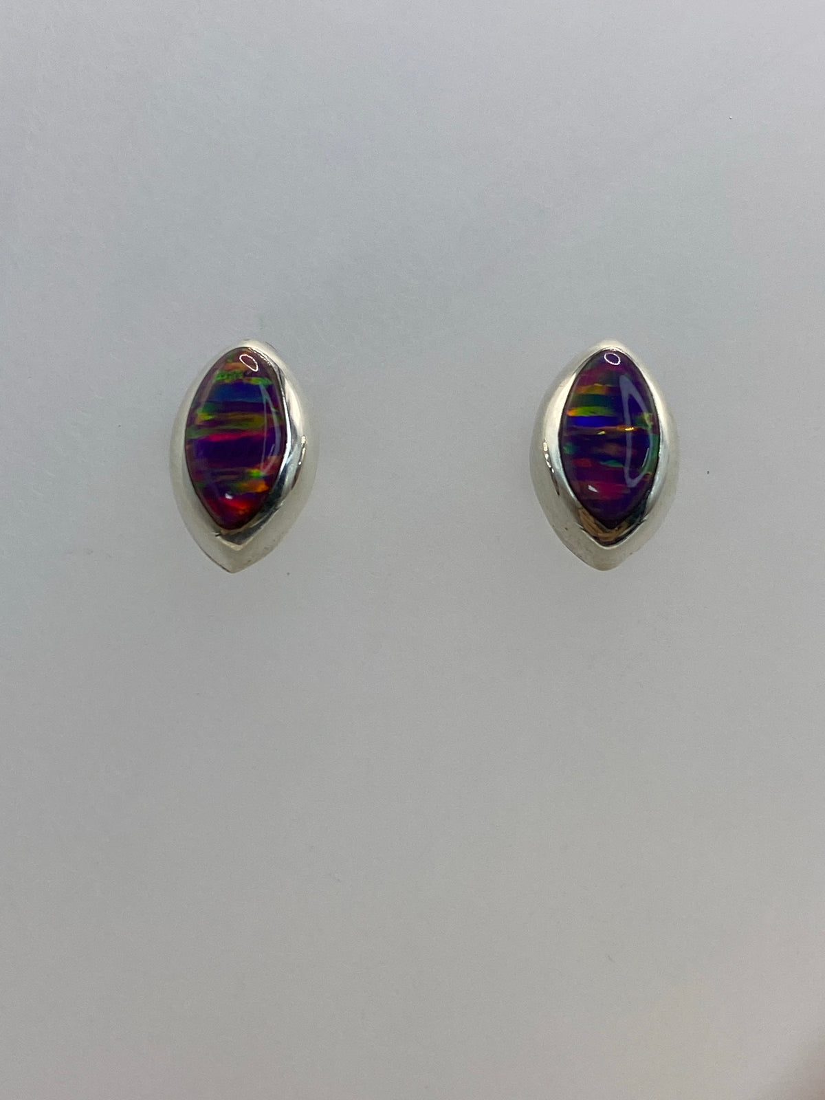 Detalle de la iridiscencia morada y anaranjada del ópalo engastado en plata